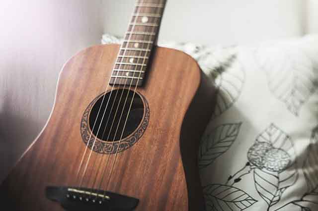 ¿Qué es la musicoterapia y como puede ayudar a las personas? Guitarra sobre un cojín. 